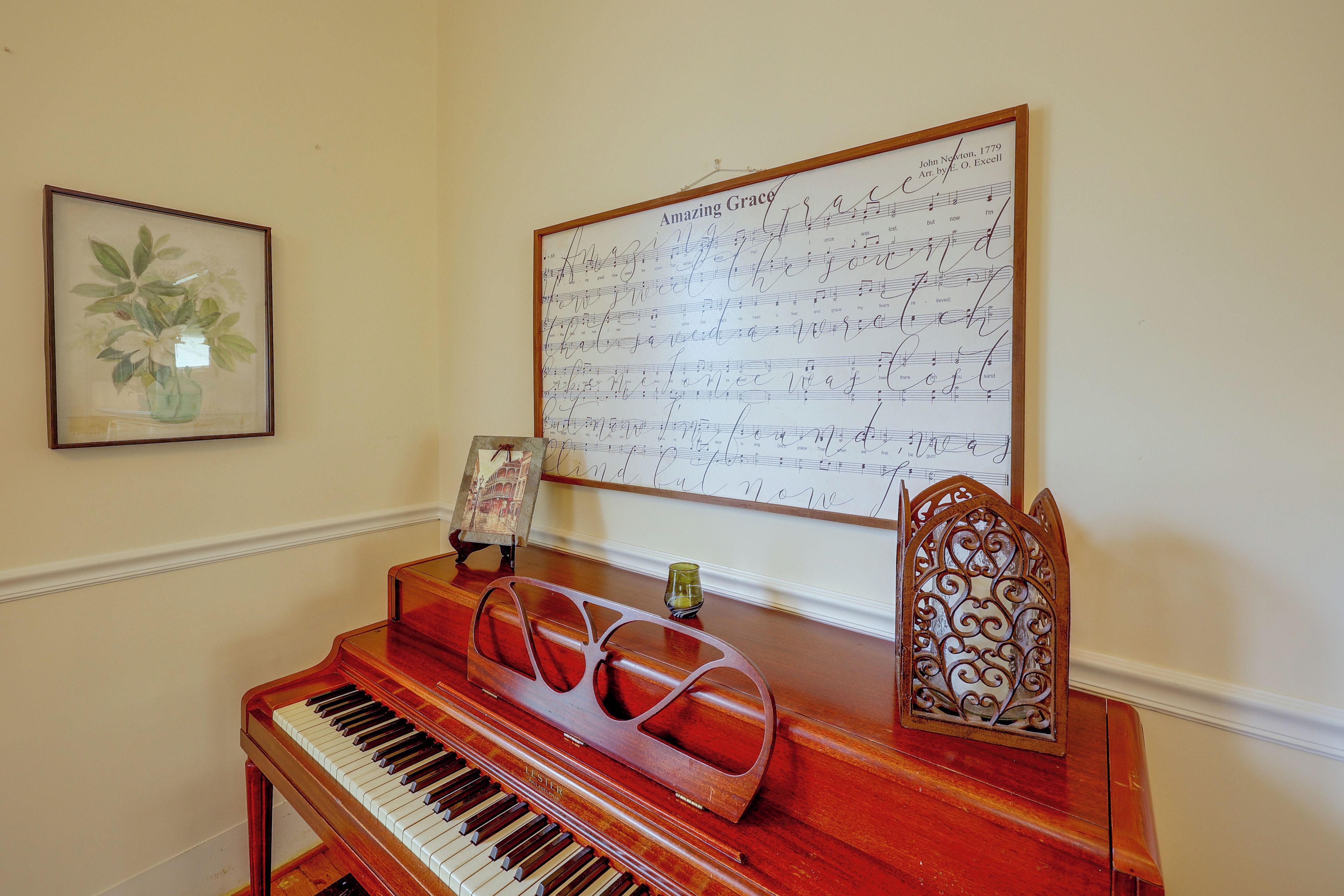Un piano, avec des partitions musicales accrochées au mur derrière.