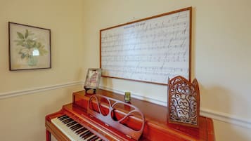 Un piano con partituras musicales en la pared detrás.