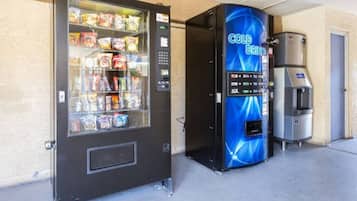 A vending machine with a blue front and a coin-operated beverage dispenser.