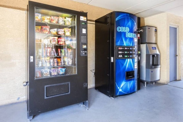 A vending machine with a blue front and a coin-operated beverage dispenser.