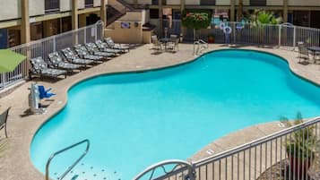 A swimming pool with lounge chairs and a staircase leading to a building.