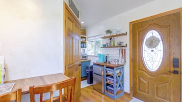 A compact kitchen with wooden cabinetry, a built-in oven, and a coffee maker.