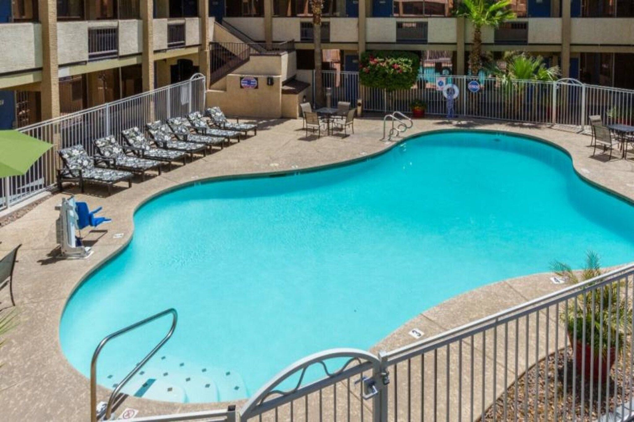 A swimming pool with lounge chairs and a staircase leading to a building.