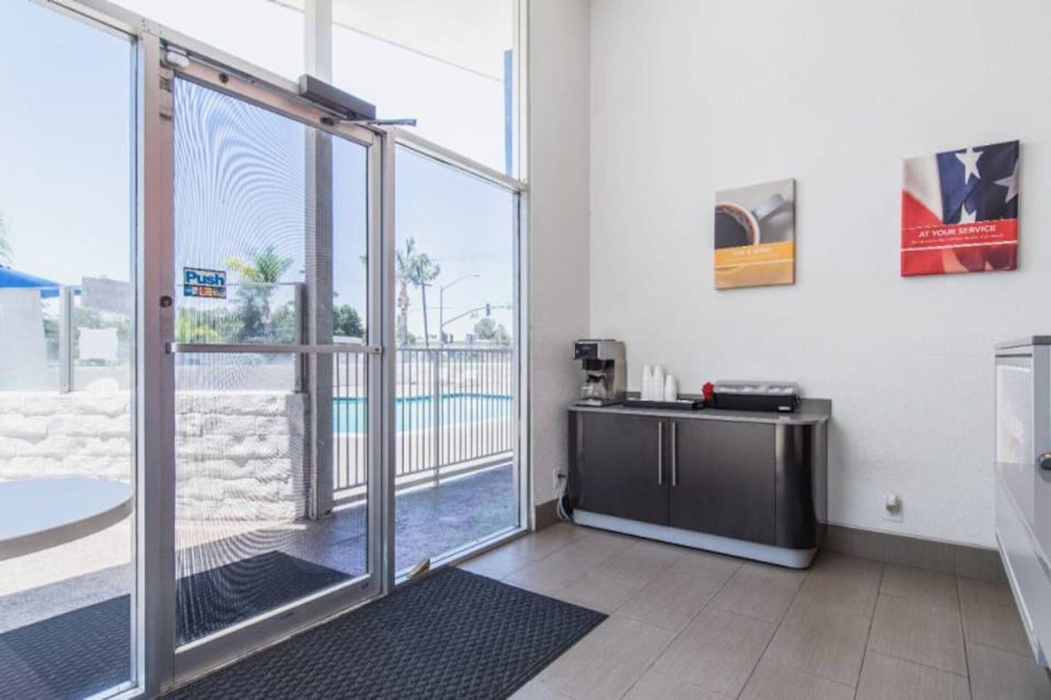 A modern interior with a sliding glass door leading outside, a coffee machine, and a small kitchenette area.