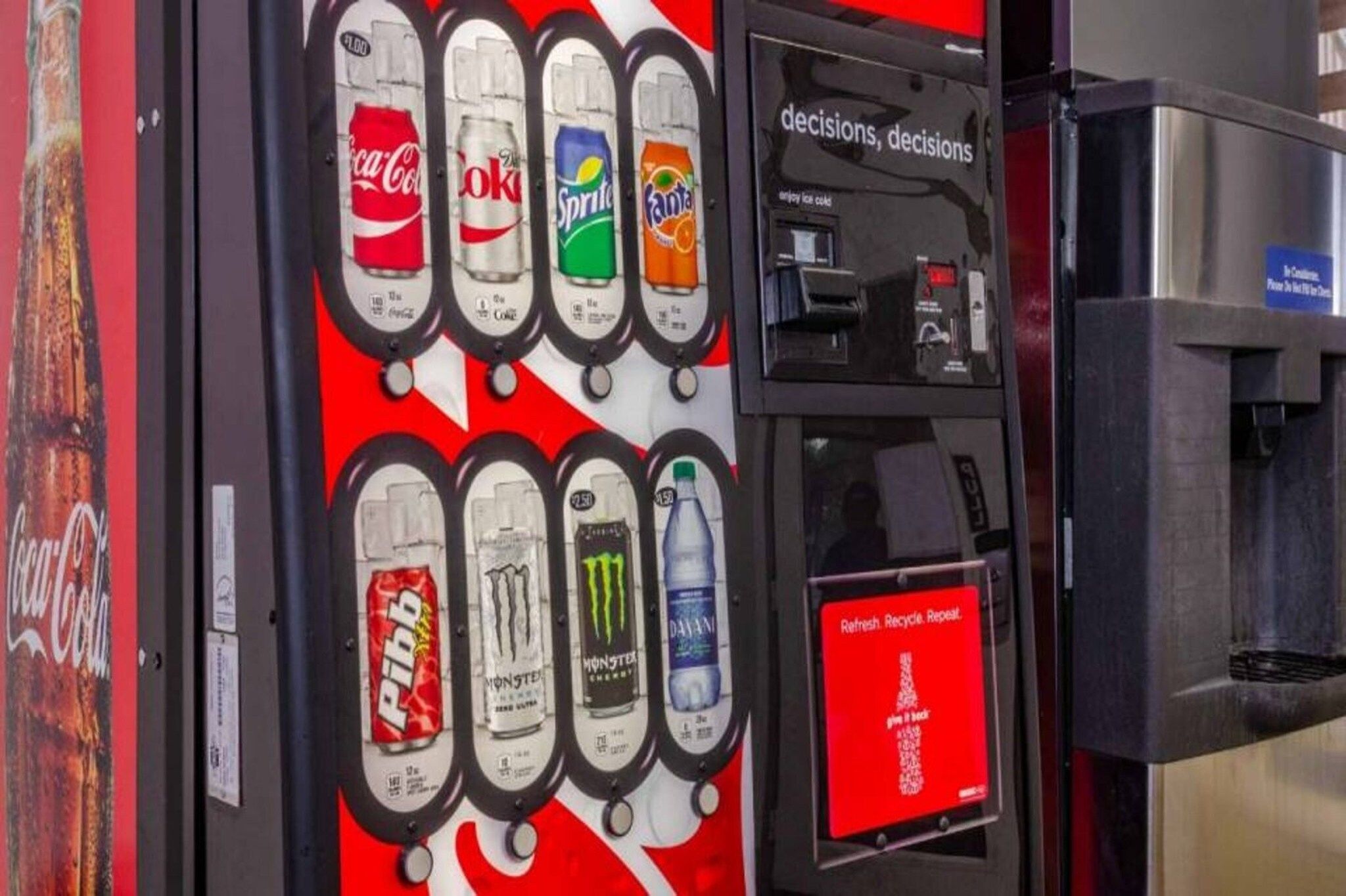 Ein Getränkeautomat mit verschiedenen Auswahlmöglichkeiten, darunter Coca-Cola, Sprite, Fanta und Energy-Drinks.