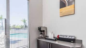 A reception area with a coffee machine, a water dispenser, and a small counter.