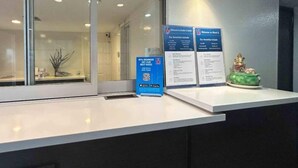 Una reception con cartelli informativi, un codice QR e un piccolo elemento decorativo.