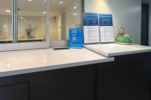 A reception desk with informational signs, a QR code, and a small decorative item. - 2 Queen Beds|Mobil Access|Micfridg (Buena Park)