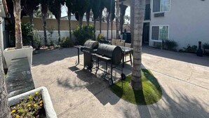 Una terrazza esterna con un barbecue e un tavolo.