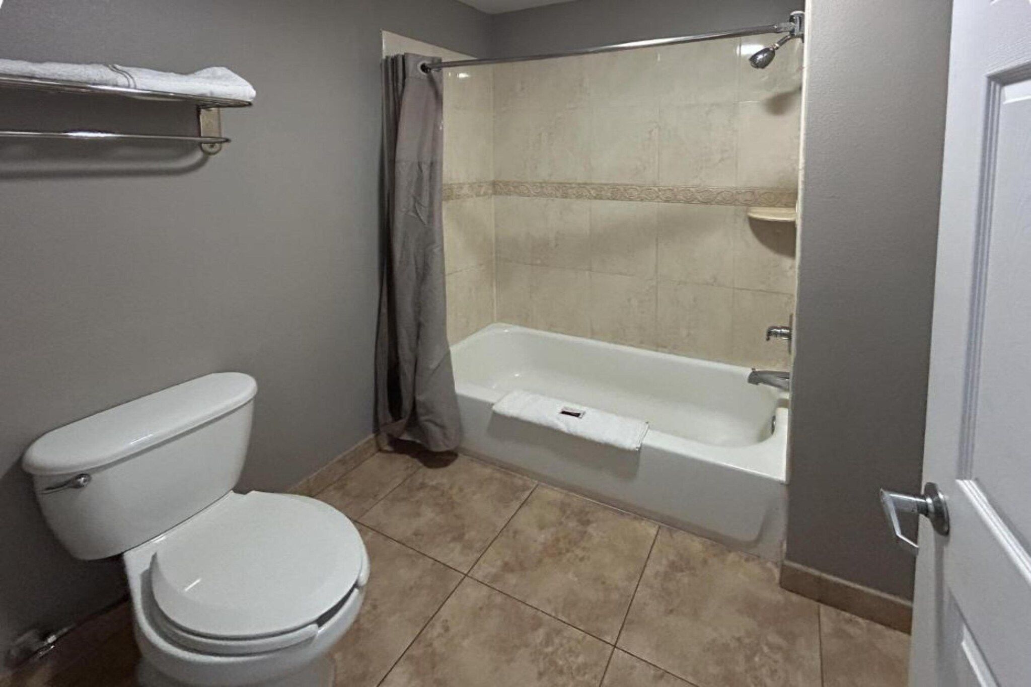 Un baño con inodoro, bañera y cortina de ducha.