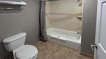 A bathroom with a toilet, a bathtub, and a shower curtain.