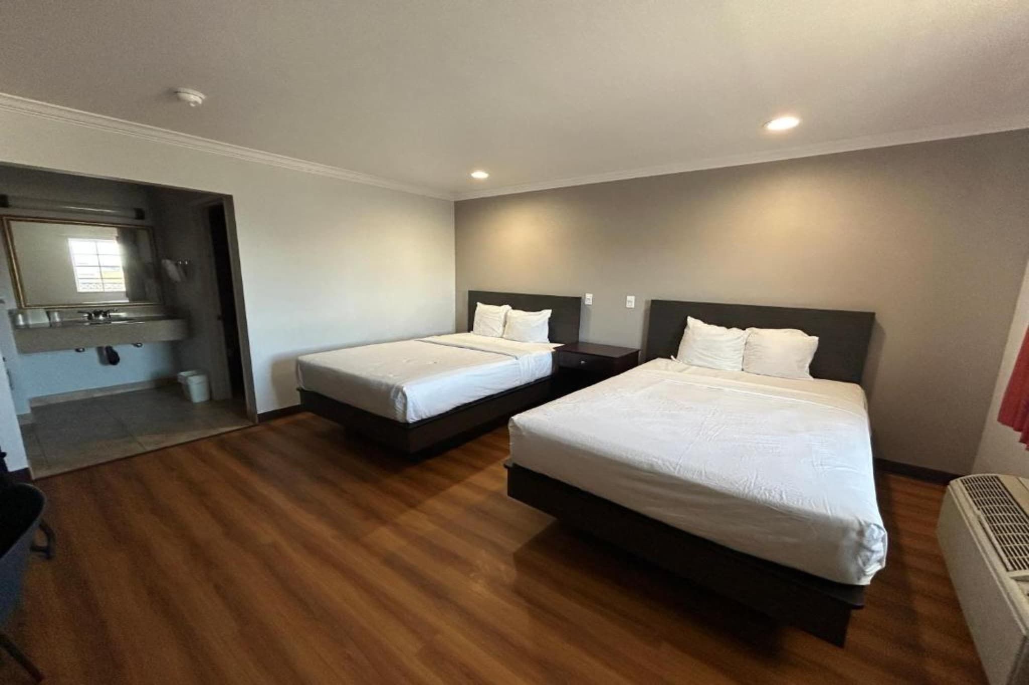 Une chambre d’hôtel avec deux lits, une salle de bain et un petit coin salon.