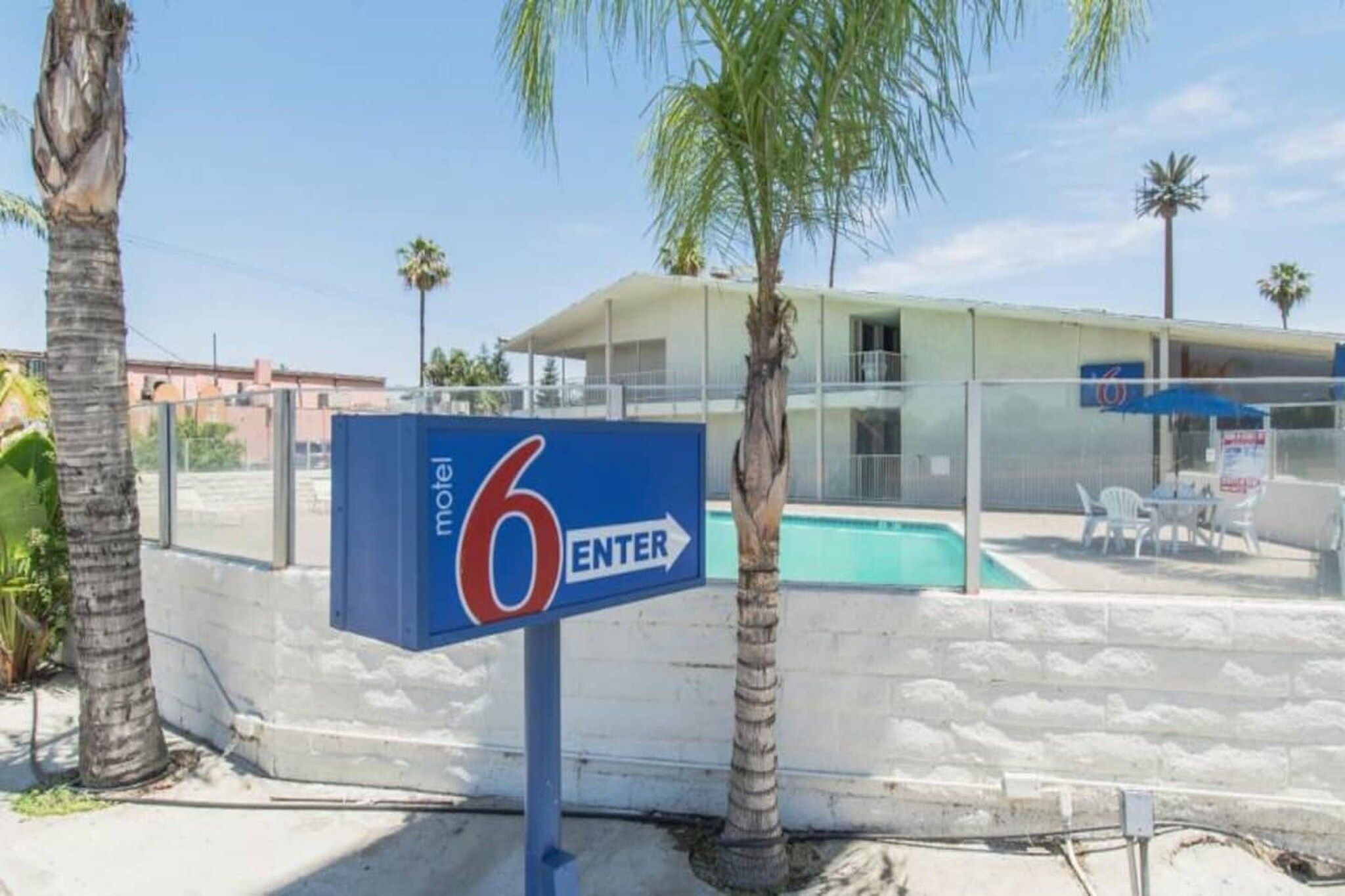 Señal de motel con un área de piscina al fondo.