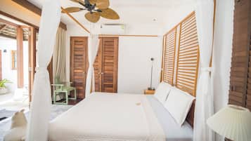Une chambre à coucher avec un lit à baldaquin, des volets en bois et un ventilateur de plafond.