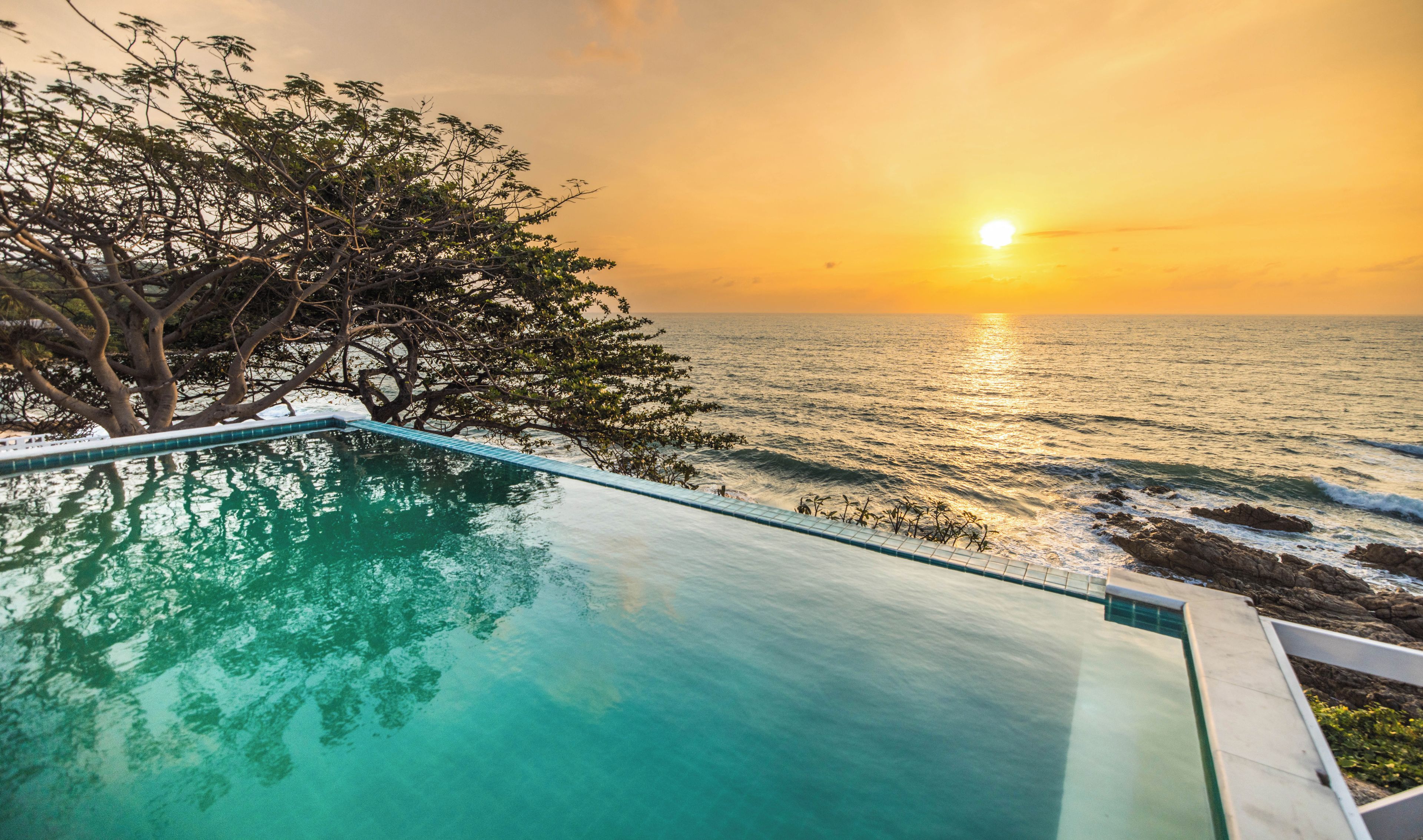 Une vue dégagée sur une piscine, avec un coucher de soleil en arrière-plan.