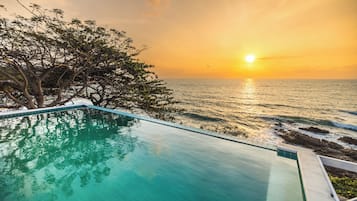 Une vue dégagée sur une piscine, avec un coucher de soleil en arrière-plan.