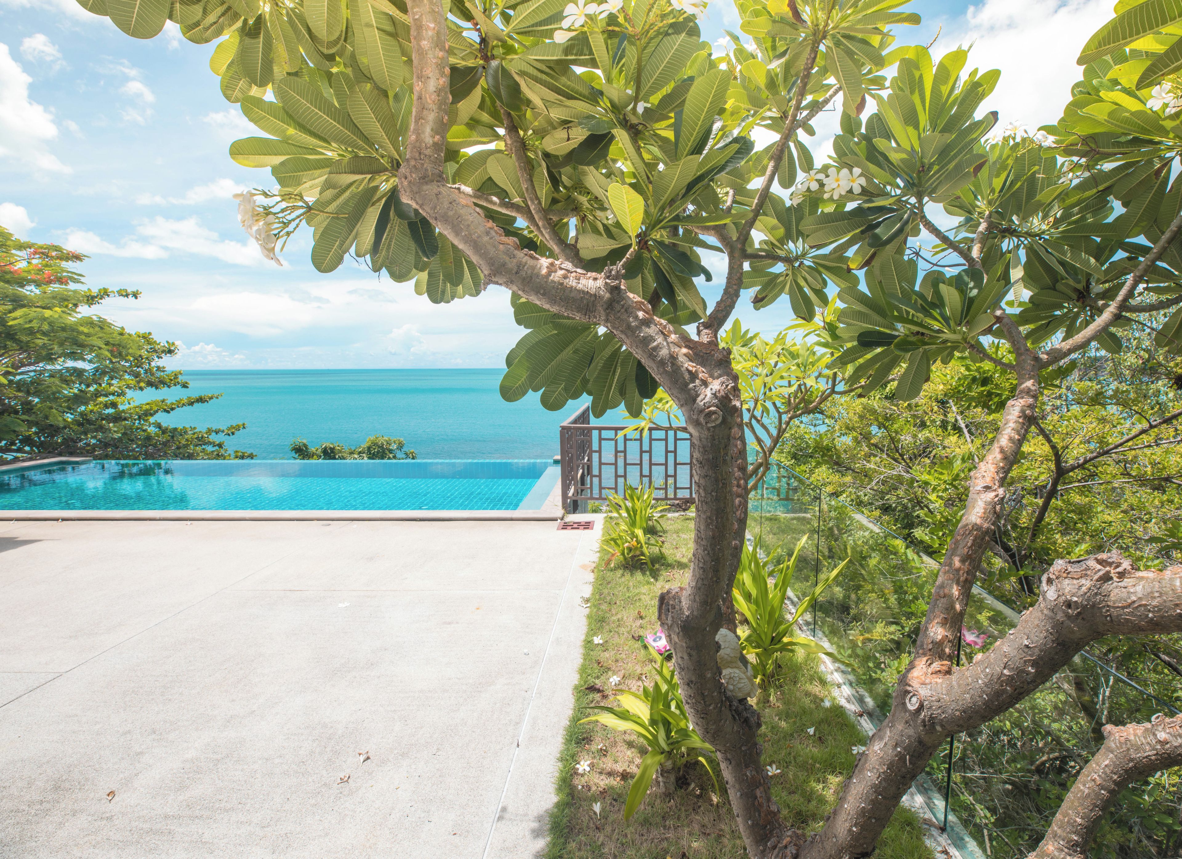 A clear view of a swimming pool with a view of the ocean.