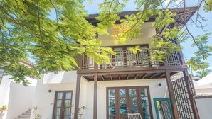A two-story building with a balcony, large windows, and potted plants. - Koh Samui frontline sea view 5-bedroom (Koh Samui)