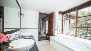 A modern bathroom with two sinks, a large bathtub, and a window with a view of trees. - Koh Samui frontline sea view 5-bedroom (Koh Samui)
