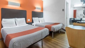Una habitación de hotel con dos camas, un escritorio y una silla.