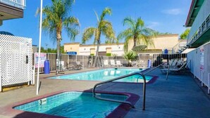 A swimming pool area with a diving board, lounge chairs, and palm trees in the background. - 2 Queen Beds | Non-Smoking, Kitchen (Fresno CA)
