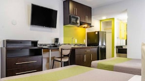 A hotel room with two beds, a desk, a chair, a television, a microwave, a refrigerator, and a sink. - 2 Queen Beds | Non-Smoking, Kitchen (Fresno CA)
