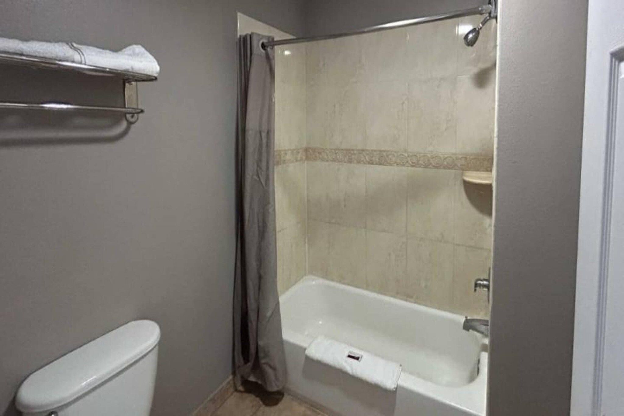 A bathroom with a bathtub, toilet, and a shower curtain.