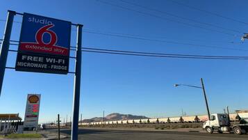 A Studio 6 Extended Stay hotel sign with amenities like free Wi-Fi, microwave, and fridge.