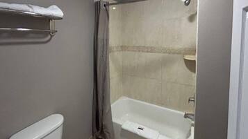 Une salle de bain avec une baignoire, des toilettes et un rideau de douche.