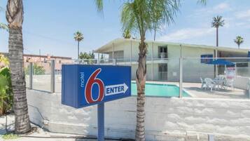 Señal de motel con un área de piscina al fondo.