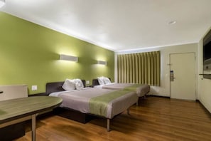 Una habitación de hotel con dos camas, un escritorio y una puerta.