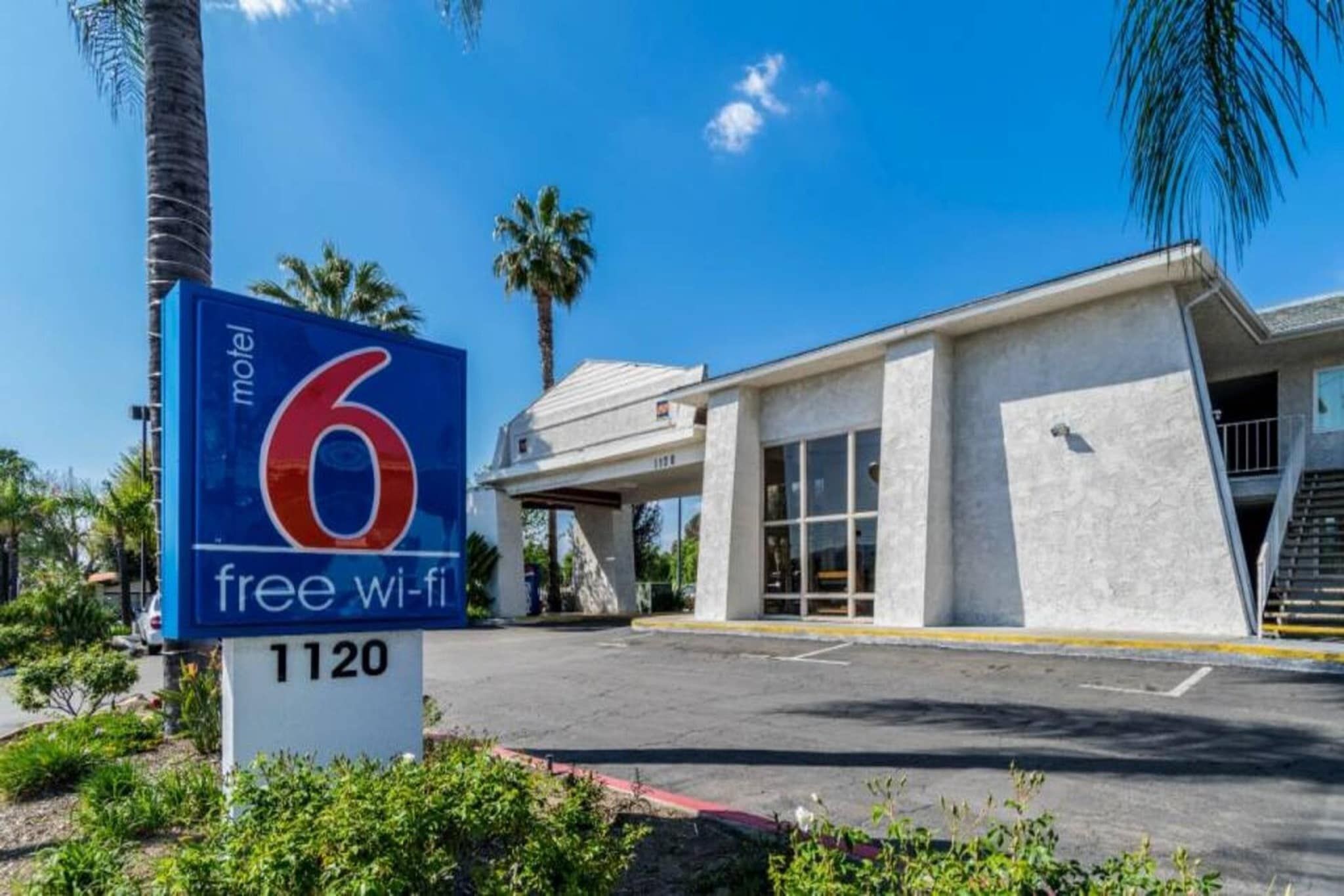 Letrero de motel con el número 6 y un símbolo de Wi-Fi gratuito, que indica el nombre del establecimiento y sus servicios.