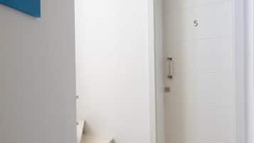 Eine weiße Tür mit der Nummer 5, eine Treppe, die zu einer oberen Etage führt, und ein Gemälde an der Wand.