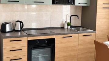 A modern kitchen with a built-in microwave, oven, and sink.