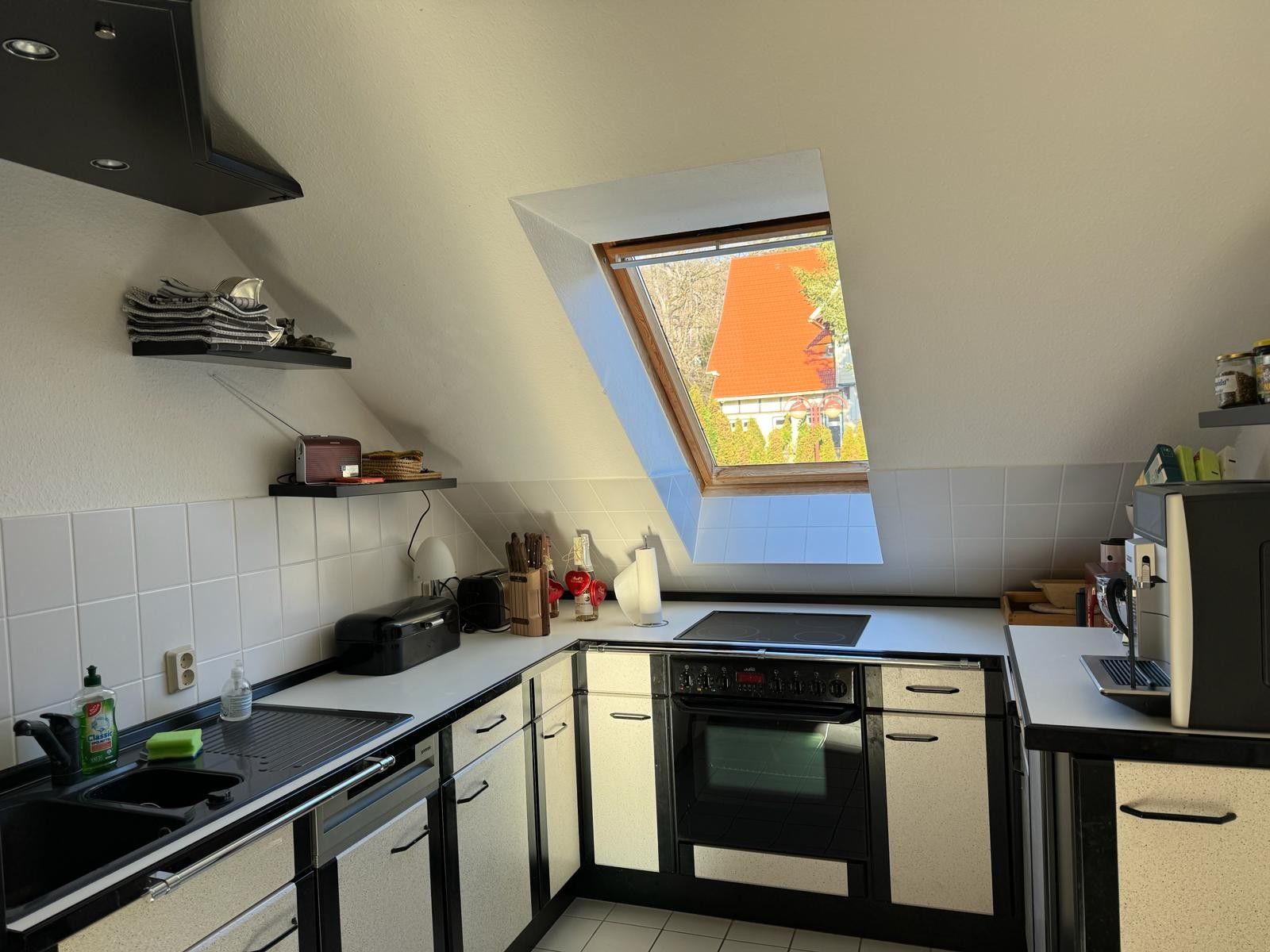 Eine moderne Küche mit einem Oberlicht, einem eingebauten Ofen und einer Spüle.