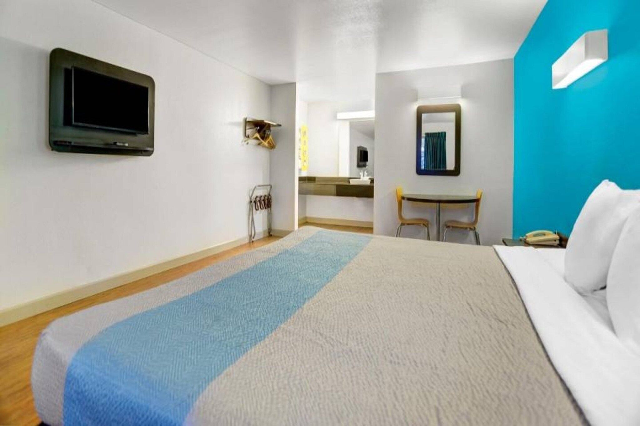 Hotellihuone, jossa on sänky, työpöytä, tuoli, televisio ja kylpyhuone.