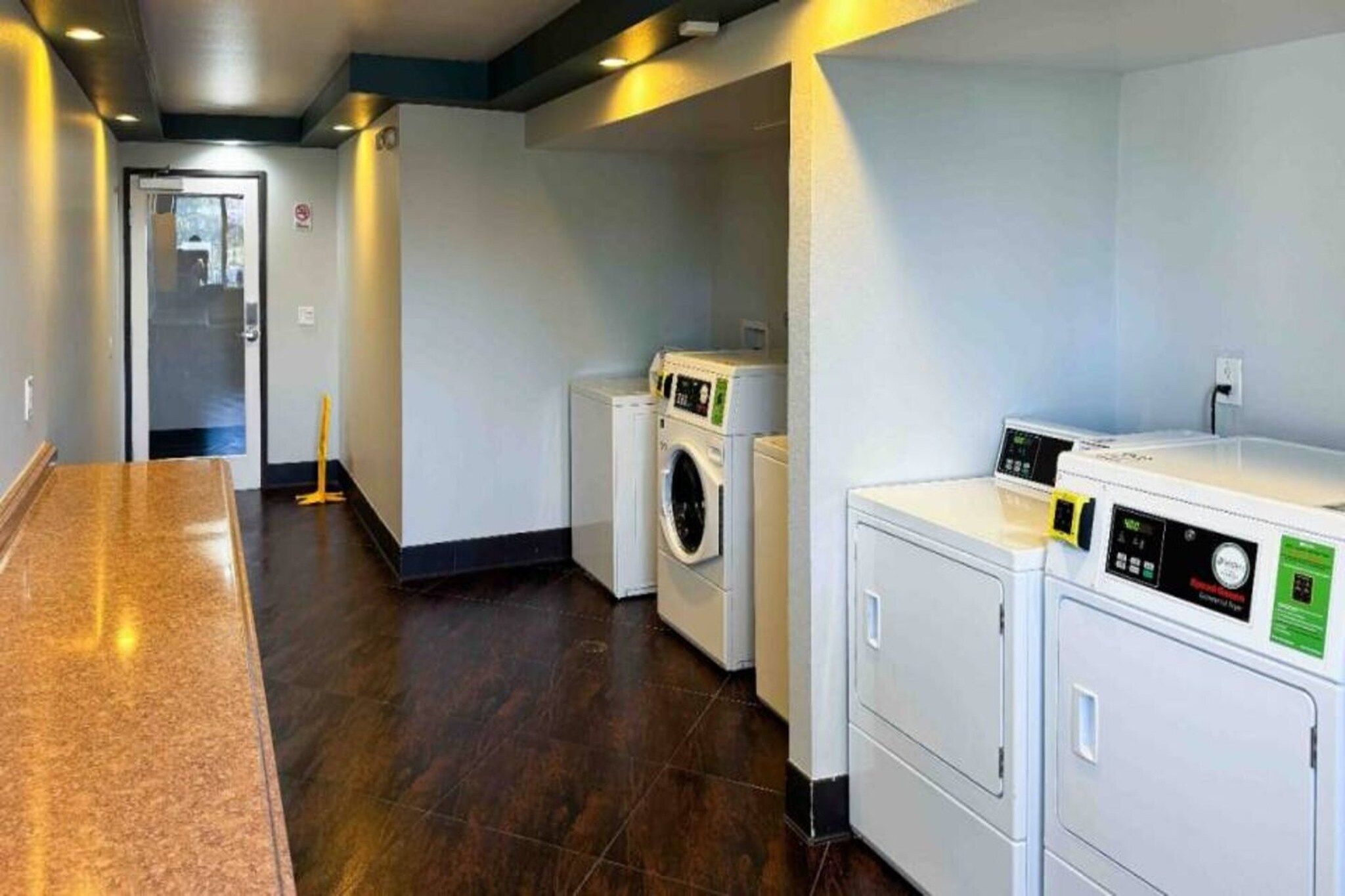 A laundry room with a washing machine, dryer, and stacked laundry baskets.