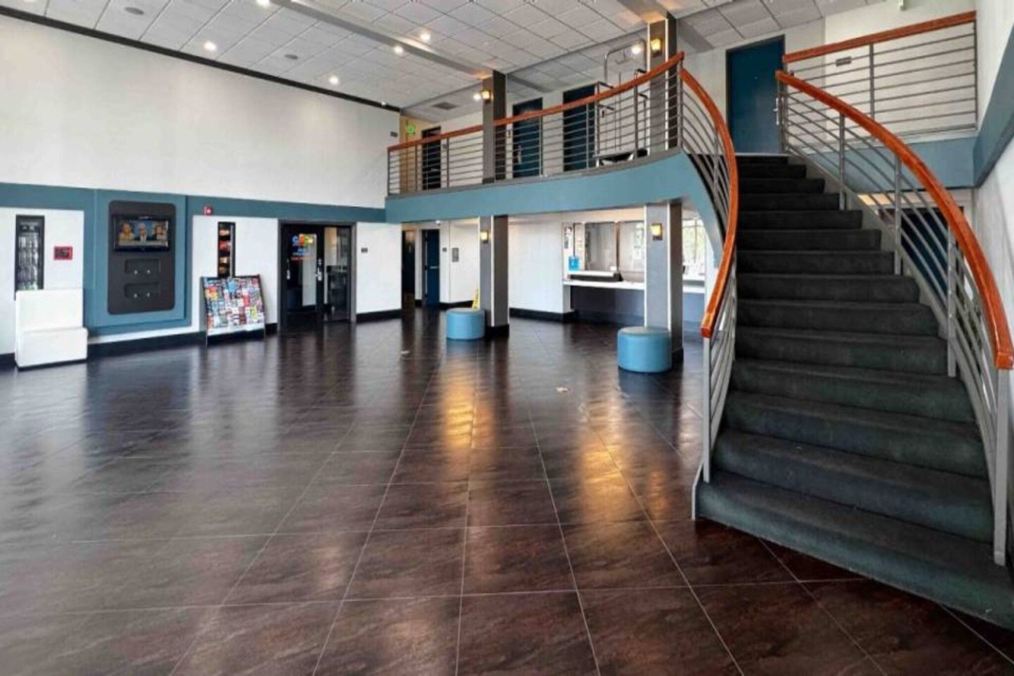 Amplio espacio interior con escalera y mostrador de recepción.