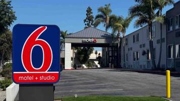 A motel entrance with a prominent sign indicating it is number 6.