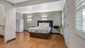 Een slaapkamer met een bed, een nachtkastje, een wandlamp en een ingebouwde heater.