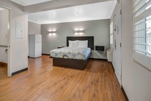 Un dormitorio con cama, mesita de noche, luz empotrada en la pared y calefacción integrada.