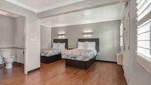 A hotel room with two beds, a toilet, and a window with blinds. - 2 Queen Beds|Mobility|Tub|Micfridg (Ontario)