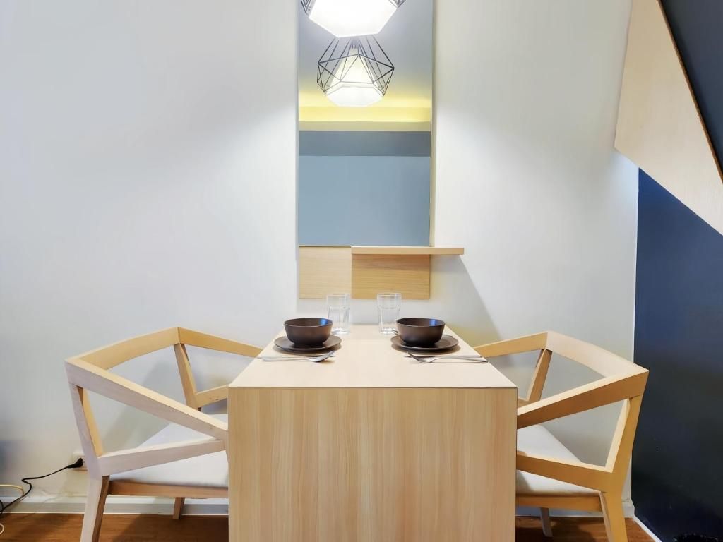 A dining area with a rectangular table, four chairs, two bowls, and two glasses.