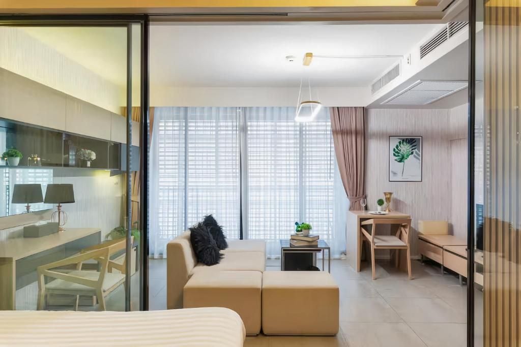 Ein modernes Hotelzimmer mit Bett, Sofa, Schreibtisch und einem kleinen Tisch.