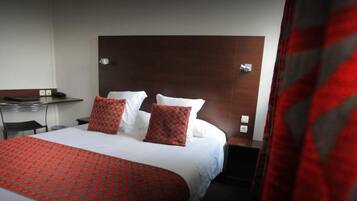 Ein Hotelzimmer mit einem großen Bett, einem Schreibtisch und einem Stuhl.