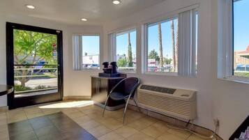 A room with a large window, a radiator, and a chair.