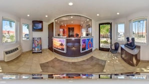 A reception area with a curved counter, a television, and a large window. - 2 Full Beds | Non-Smoking (Riverside)