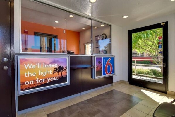 A hotel reception area with a large digital display advertising a room service.