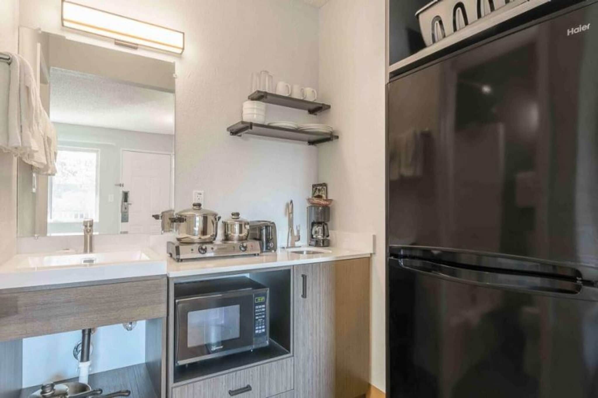 Eine moderne Küche mit Backofen, Mikrowelle und einem Edelstahl-Kühlschrank.