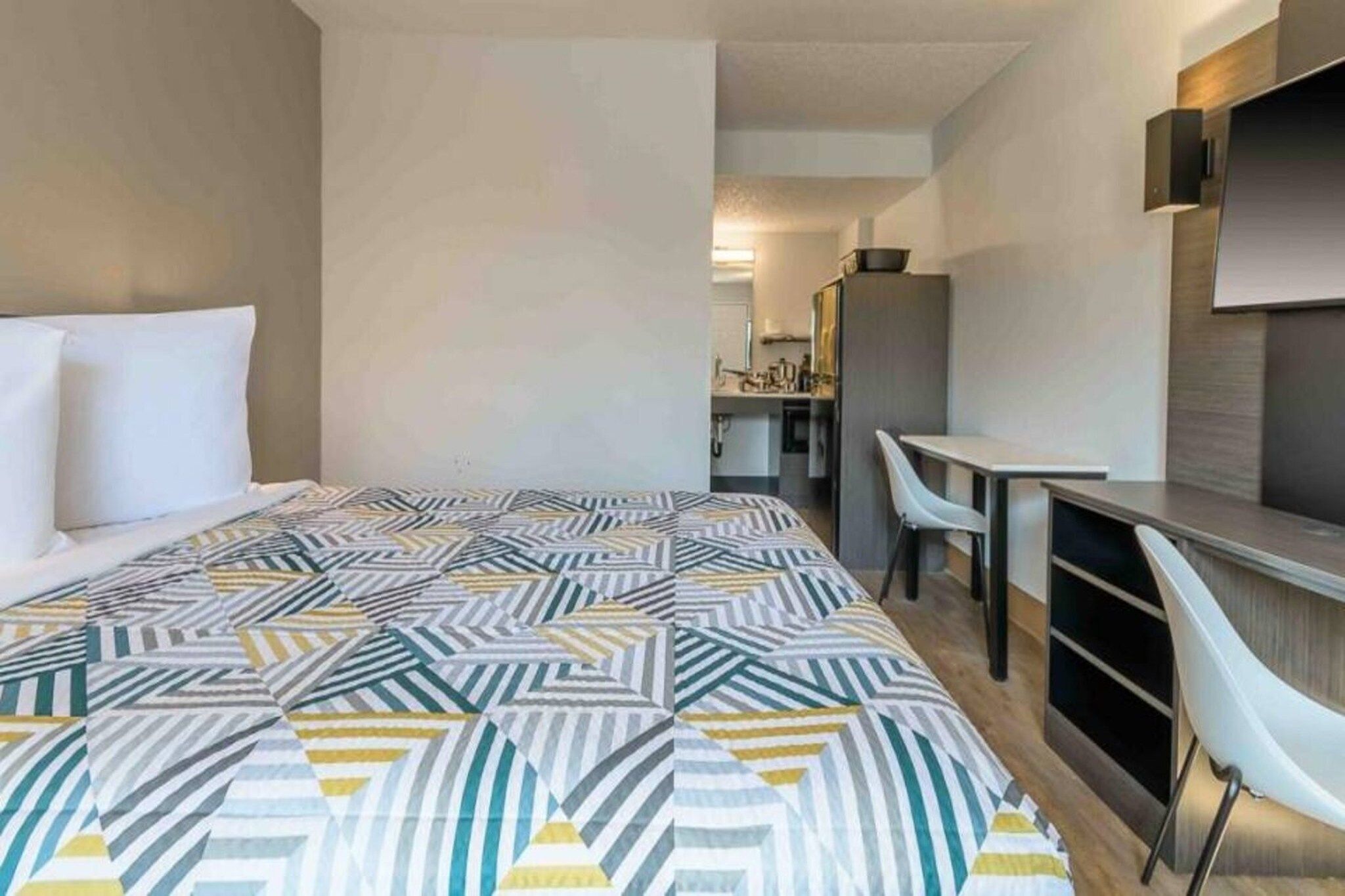 Ein Hotelzimmer mit einem Bett, einem Schreibtisch und einem Stuhl.
